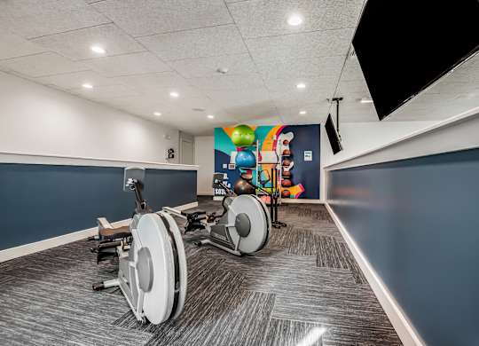 A room with a blue wall and a treadmill.