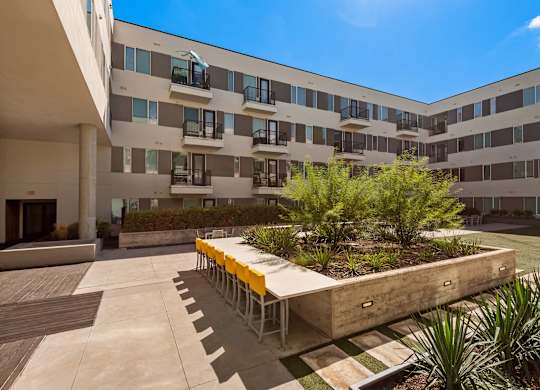 A modern building with a courtyard and a wooden table.