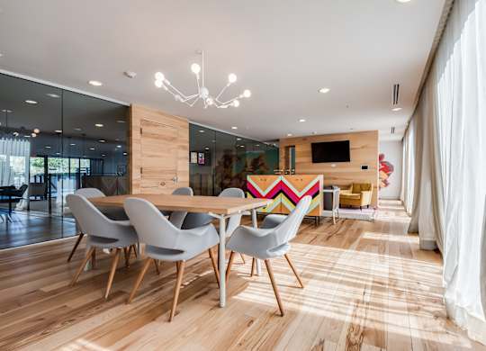 A modern dining room with a wooden table and chairs.