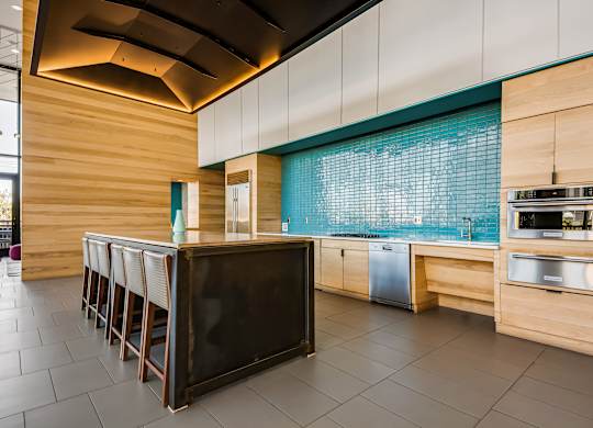 A modern kitchen with a wooden bar and stainless steel appliances.