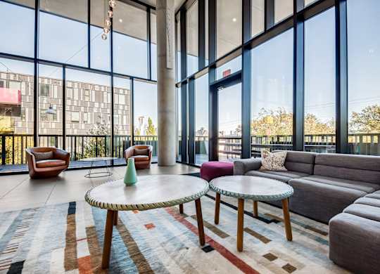 A living room with a large window and a grey couch.