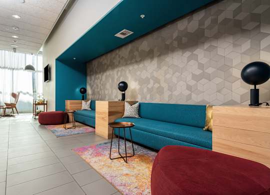 A modern living room with a blue couch and a wooden floor.