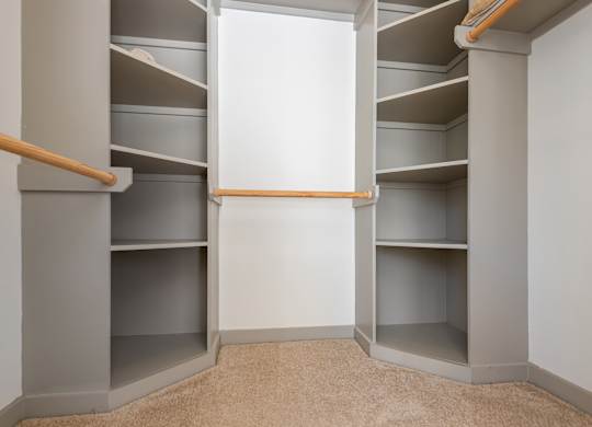 A walk-in closet with shelves and a carpeted floor.