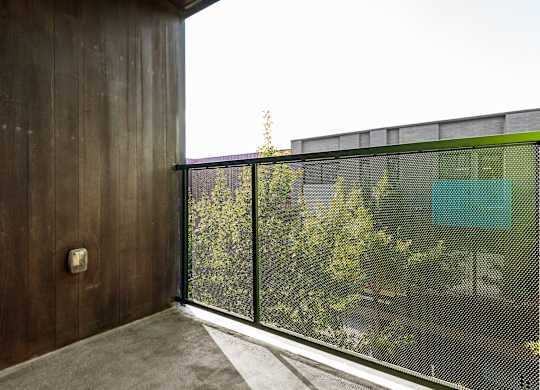 A balcony with a wooden wall and a mesh screen.
