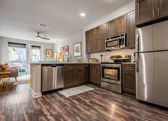 A modern kitchen with stainless steel appliances and wooden floors.