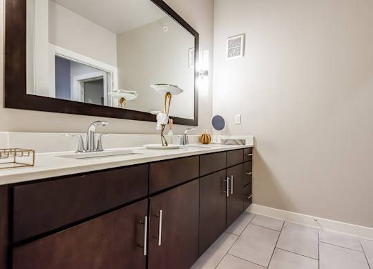 A bathroom with a sink, mirror, and cabinets.