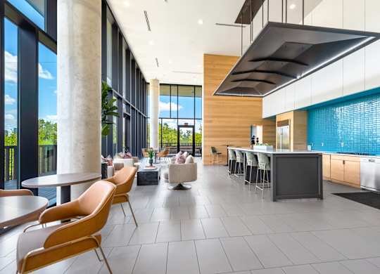 Resident Lounge with Floor-to-Ceiling Windows, Kitchen Area, and Cozy Seating