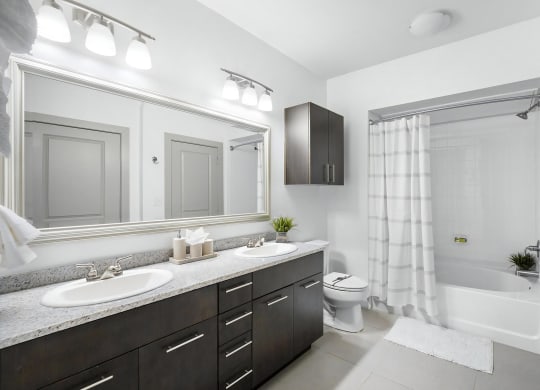 Bright Bathroom with Dual Vanities, Tile Floors, and Shower-Tub Combo