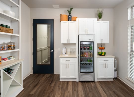 a kitchen with white cabinets and a refrigerator and a door