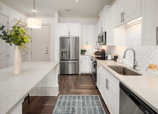 a large white kitchen with stainless steel appliances