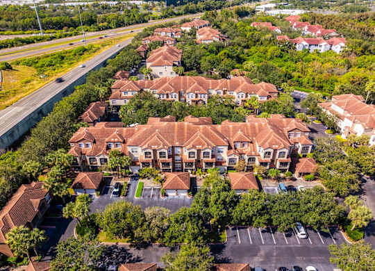 Aerial of residential buildings and parking area alongside highway access