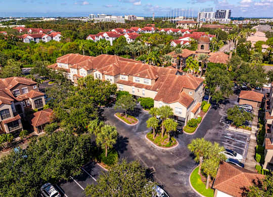 Aerial of apartment buildings with terracotta roofs and parking areas