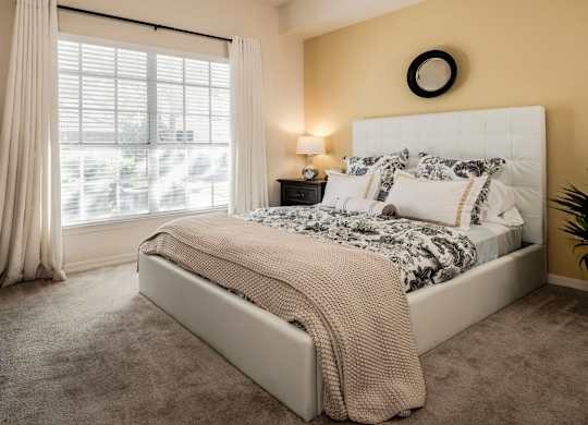 Bright bedroom with upholstered bed and large window