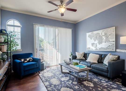 Living room with blue walls, leather sofa and balcony light
