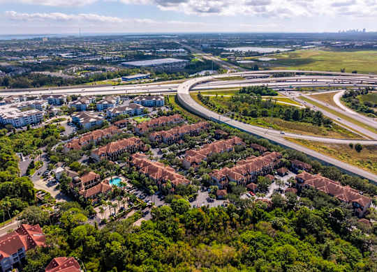 Overhead view of community surrounded by trees and connecting roadways