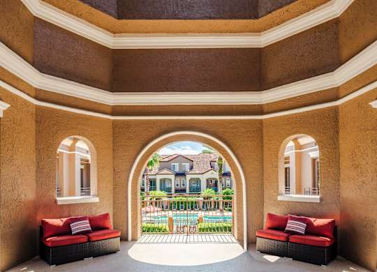 Covered seating area overlooking the pool and courtyard, perfect for relaxing outdoors.