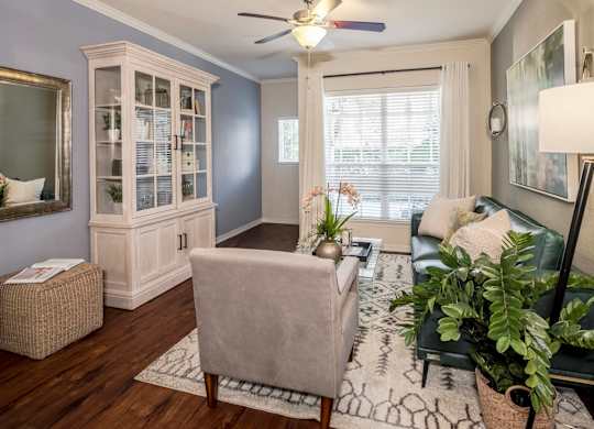 Cozy living room with hutch, armchair, and window light