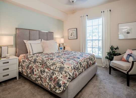 Bedroom with upholstered headboard, floral bedding and soft natural light