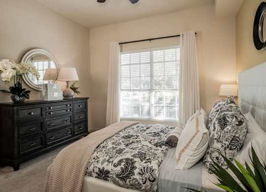 Cozy bedroom with dresser, mirror and soft window light