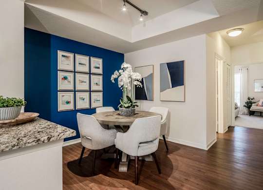 Dining area with gallery wall, round table and orchid centerpiece