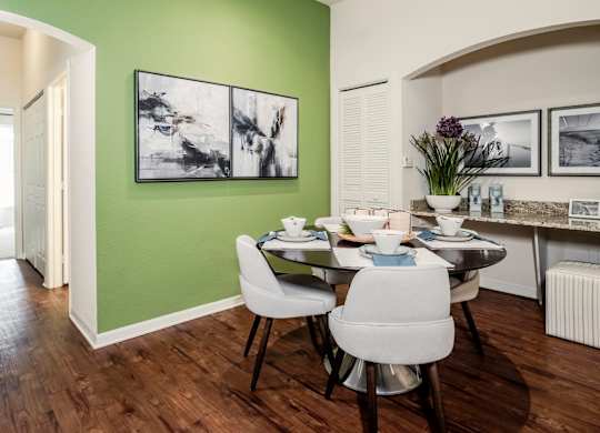 Dining nook with green accent wall and round table