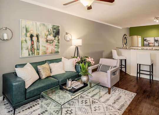 Stylish living room with sofa, accent chair, artwork, and glass coffee table