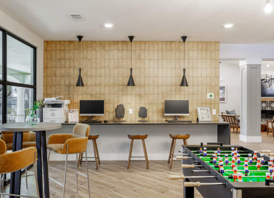 a games room with a foosball table and computer monitors
