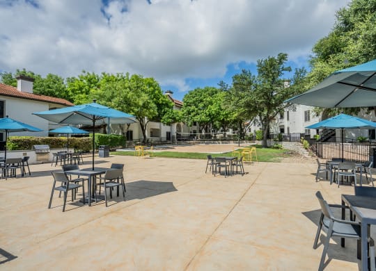 a patio with tables and chairs and umbrellas