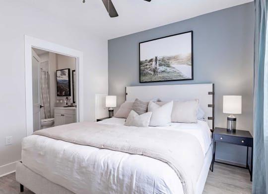 Modern bedroom with ceiling fan and en-suite bathroom at Novel Cary