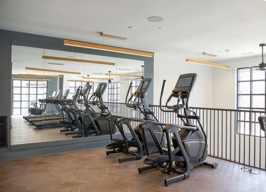 Second-story cardio area with modern elliptical machines at Novel Cary