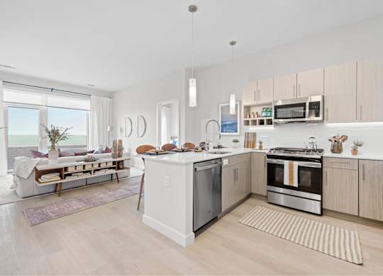 A modern kitchen with a dining area and a view of the beach.