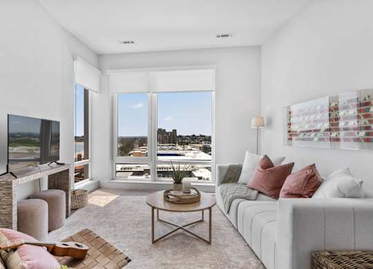A living room with a flat screen TV and a view of the city.