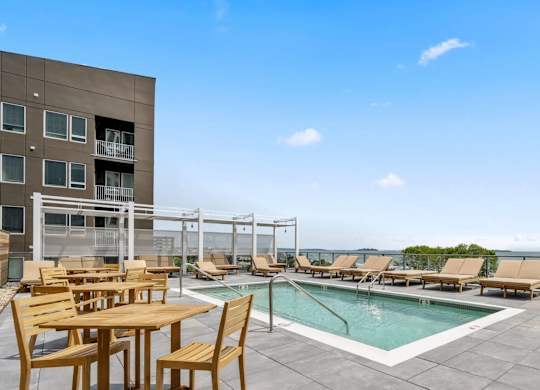 A poolside table and chairs are set up on a patio.