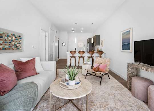 A living room with a white couch, a coffee table, and a painting on the wall.