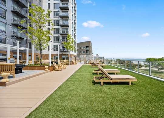A grassy area with benches and a fence in front of a building.