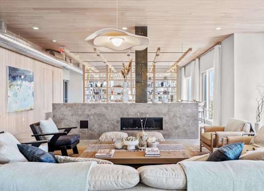 A modern living room with a fireplace and a large painting on the wall.