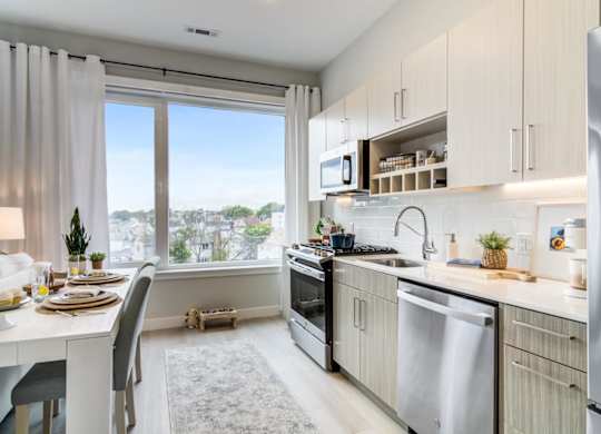 A modern kitchen with a dining table set for two.