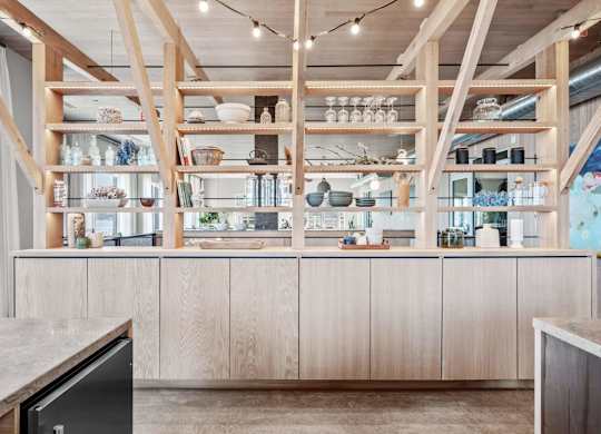A kitchen with wooden shelves and cabinets.
