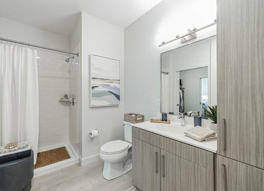 A white bathroom with a toilet, sink, and shower.