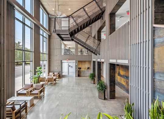 A modern atrium with a staircase and seating area.