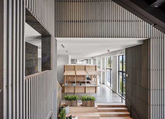 A modern interior with a long hallway and a staircase on the left.