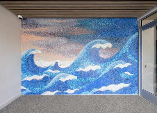 A painting of blue waves on a wall.