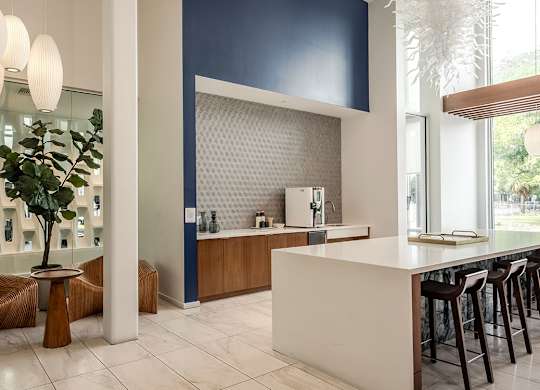 Tenant lounge area with modern seating and kitchen area at Pearl Flagler Village