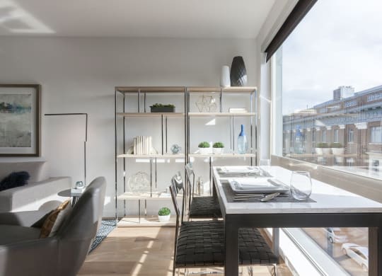 a living room with a table and chairs and a large window