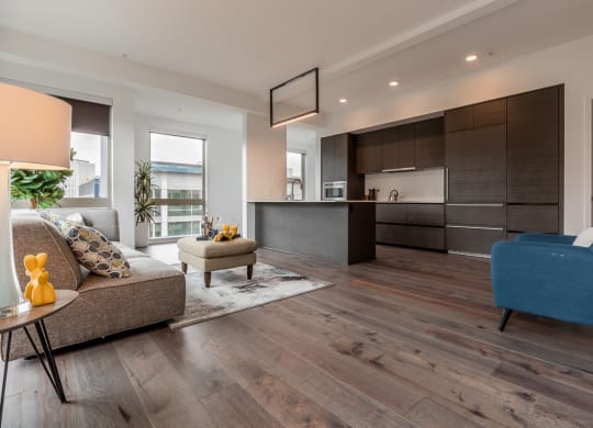 a living room with a couch and a table in front of a kitchen