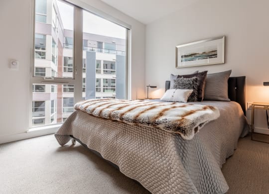 a bedroom with a bed and a large window