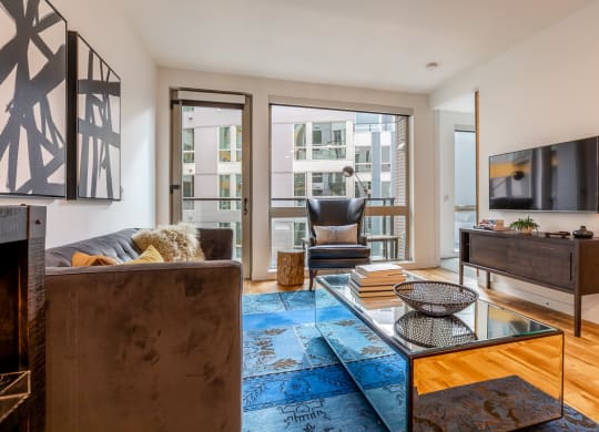 a living room with a couch and a glass coffee table and a television