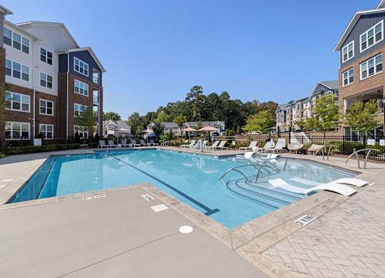 A large swimming pool surrounded by apartment buildings.