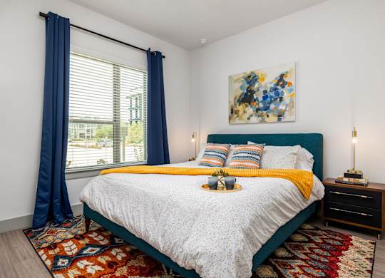 Rhythm bedroom with a large bed and a painting on the wall.