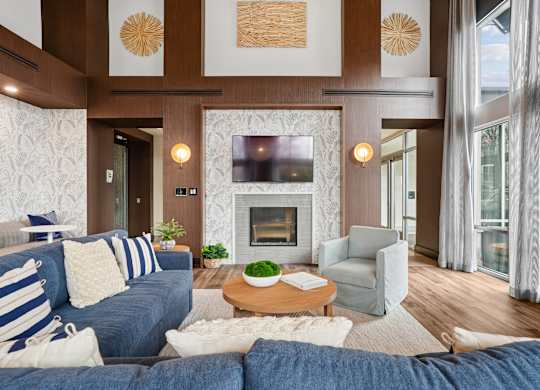 A living room with a blue couch and a fireplace.